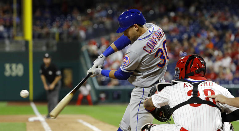 New York Mets' Michael Conforto, left, hits a two-run home run off Philadelphia Phillies relief pitcher Hector Neris during the ninth inning of a baseball game Friday, May 11, 2018, in Philadelphia. Phillies Mets