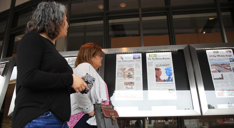 Newseum visitors browse newspaper front pages displayed outside the museum in Washington. Newseum visitors browse newspaper front pages displayed outside the museum in Washington.