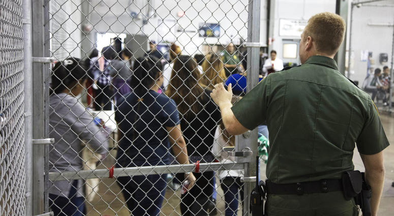 In this photo provided by U.S. Customs and Border Protection, a U.S. Border Patrol agent watches as people who've been taken into custody related to cases of illegal entry into the United States, stand in line at a facility in McAllen, Texas. In this photo provided by U.S. Customs and Border Protection, a U.S. Border Patrol agent watches as people who've been taken into custody related to cases of illegal entry into the United States, stand in line at a facility in McAllen, Texas.