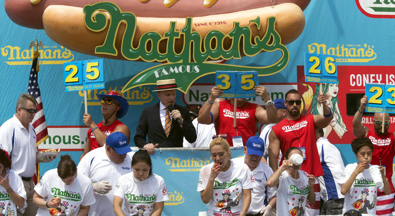 The competitors eat hot dogs during the women's competition of the Nathan's Famous Fourth of July hot dog eating contest, Wednesday, July 4, 2018, in New York's Coney Island. The competitors eat hot dogs during the women's competition of the Nathan's Famous Fourth of July hot dog eating contest, Wednesday, July 4, 2018, in New York's Coney Island.