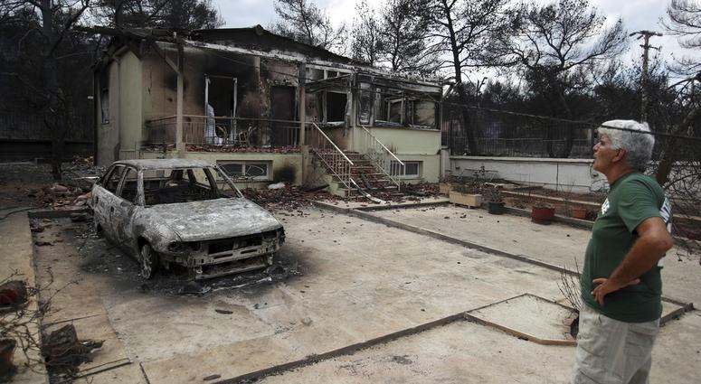 A man looks the burned house of his sister in Agios Andreas, east of Athens, Tuesday, July 24, 2018. A man looks the burned house of his sister in Agios Andreas, east of Athens, Tuesday, July 24, 2018.