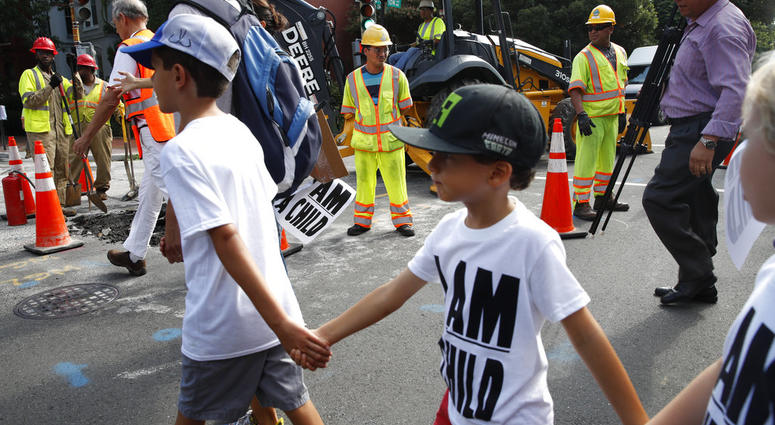 Construction workers watch as children hold hands during a march in protest of the separation of immigrant families, Thursday, July 26, 2018, on Capitol Hill in Washington. Construction workers watch as children hold hands during a march in protest of the separation of immigrant families, Thursday, July 26, 2018, on Capitol Hill in Washington.