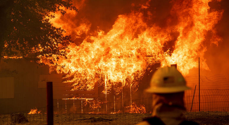 A firefighter monitors a burning outbuilding to ensure flames don't spread as the River Fire burns in Lakeport, Calif., on Monday, July 30, 2018. A firefighter monitors a burning outbuilding to ensure flames don't spread as the River Fire burns in Lakeport, Calif., on Monday, July 30, 2018.
