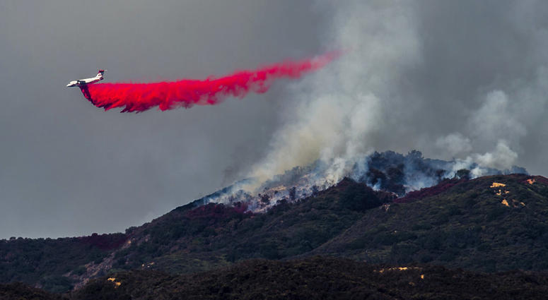 A plane drops fire retardant as firefighters continue to battle a wildfire in the Cleveland National Forest near Corona, Calif. on Tuesday, Aug. 7, 2018. A plane drops fire retardant as firefighters continue to battle a wildfire in the Cleveland National Forest near Corona, Calif. on Tuesday, Aug. 7, 2018.