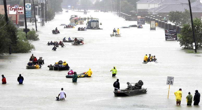 In this Aug. 28, 2017 file photo, rescue boats fill a flooded street as flood victims are evacuated as floodwaters from Tropical Storm Harvey rise in Houston. In this Aug. 28, 2017 file photo, rescue boats fill a flooded street as flood victims are evacuated as floodwaters from Tropical Storm Harvey rise in Houston.