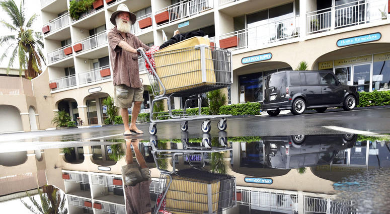 David Crocker, who is homeless, pushes his belongings past a puddle in Kihei on the Hawaiian island of Maui, Saturday, Aug. 25, 2018. David Crocker, who is homeless, pushes his belongings past a puddle in Kihei on the Hawaiian island of Maui, Saturday, Aug. 25, 2018.
