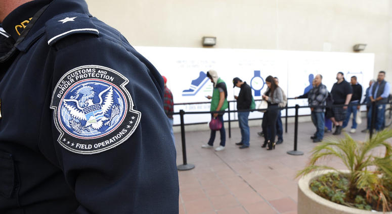 n this Dec. 10, 2015, file photo, pedestrians crossing from Mexico into the United States at the Otay Mesa Port of Entry wait in line in San Diego.