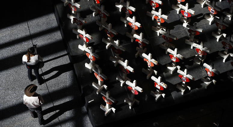 In this Sept. 25, 2018, photo, people look at a display of wooden crosses and a Star of David on display at the Clark County Government Center in Las Vegas. In this Sept. 25, 2018, photo, people look at a display of wooden crosses and a Star of David on display at the Clark County Government Center in Las Vegas.