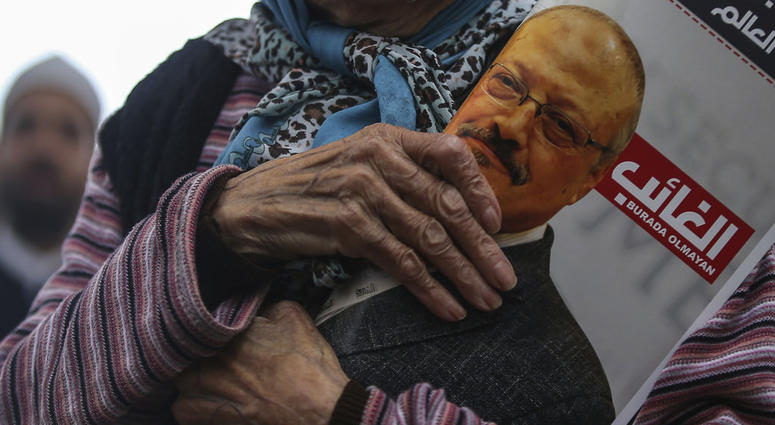 A woman holds a poster during the funeral prayers in absentia for Saudi writer Jamal Khashoggi who was killed last month in the Saudi Arabia consulate, in Istanbul, Friday, Nov. 16, 2018.