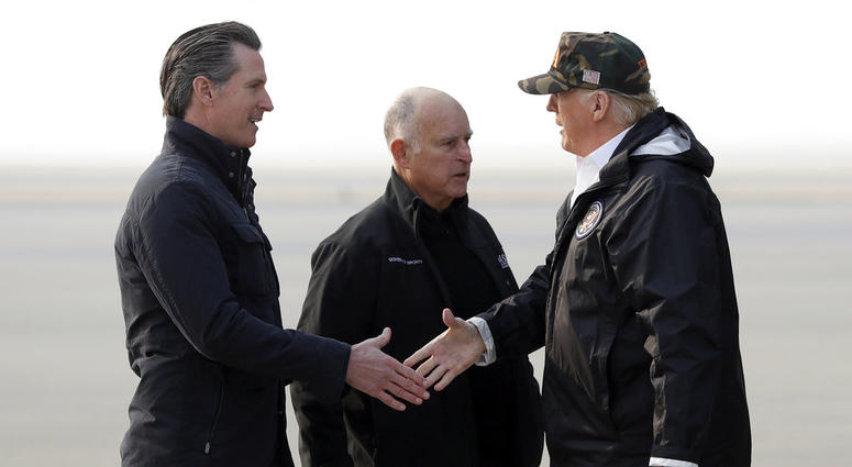 President Trump greets California Gov.-elect Gavin Newsom as he arrives on Air Force One at Beale Air Force Base for a visit to areas impacted by the wildfires as Gov. Jerry Brown stands at attention. President Donald Trump