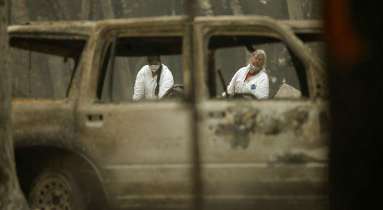 File - In this Nov. 15, 2018 file photo, investigators recover human remains at a home burned in the Camp Fire in Magalia, Calif. Authorities have deployed a powerful tool to aid in their race to identify the remains of 77 bodies burned in the wildfire.