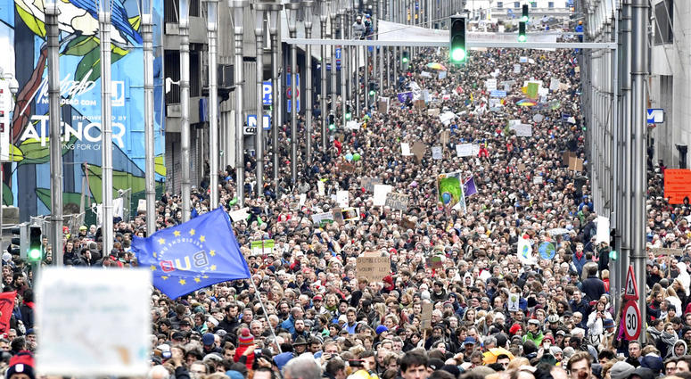 Demonstrators hold signs and wave flags as they march in the main EU quarter during a 'Claim the Climate' march in Brussels, Sunday, Dec. 2, 2018. Demonstrators hold signs and wave flags as they march in the main EU quarter during a 'Claim the Climate' march in Brussels, Sunday, Dec. 2, 2018.