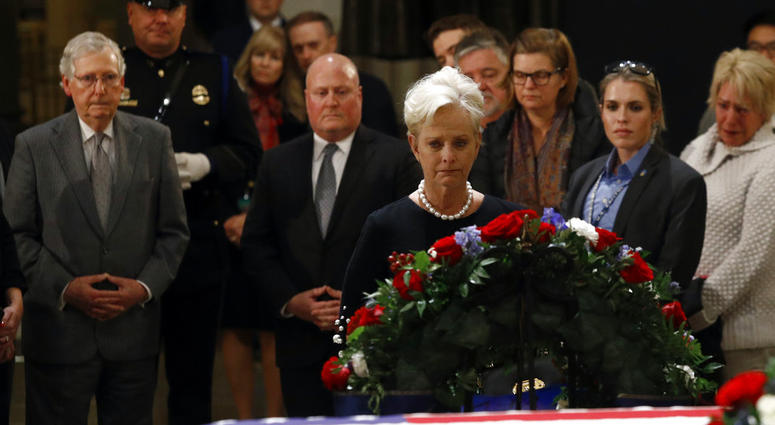Cindy McCain, center, widow of the late U.S> Sen. John McCain, R-Ariz., views the flag-draped casket of former President George H.W. Bush as he lies in state in the Capitol Rotunda in Washington, Tuesday, Dec. 4, 2018. Cindy McCain, center, widow of the late U.S> Sen. John McCain, R-Ariz., views the flag-draped casket of former President George H.W. Bush as he lies in state in the Capitol Rotunda in Washington, Tuesday, Dec. 4, 2018.