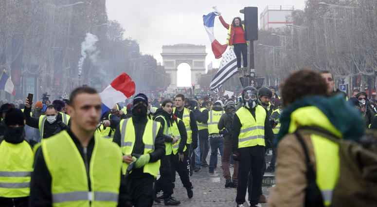 In this Nov. 24, 2018, file photo, demonstrators march on the famed Champs-Elysees avenue in Paris, France, as they protest the rising of the fuel prices. In this Nov. 24, 2018, file photo, demonstrators march on the famed Champs-Elysees avenue in Paris, France, as they protest the rising of the fuel prices.
