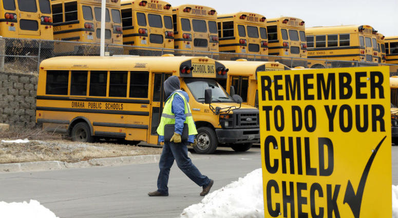 In this Dec. 20, 2018 photo, a driver walks away from the school bus parking lot after his morning shift, in Omaha, Neb. In this Dec. 20, 2018 photo, a driver walks away from the school bus parking lot after his morning shift, in Omaha, Neb.
