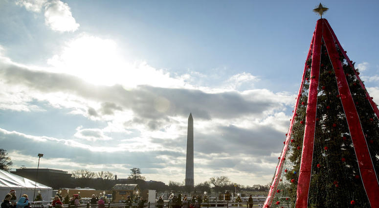 Visitors to the National Christmas Tree on the Ellipse look at holiday decorations as National Park Service employees briefly open the venue before quickly having to close again due to electrical problems, Monday, Dec. 24, 2018, in Washington. National Christmas Tree