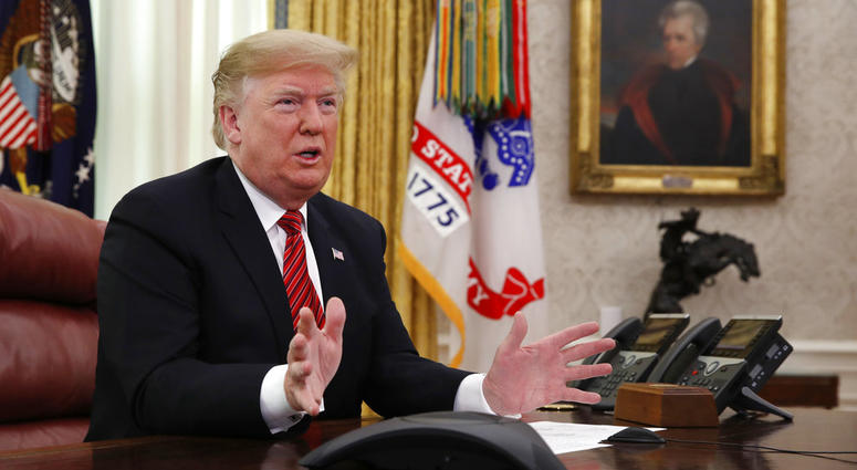 President Donald Trump greets members of the five branches of the military by video conference on Christmas Day, Tuesday, Dec. 25, 2018, in the Oval Office. President Donald Trump