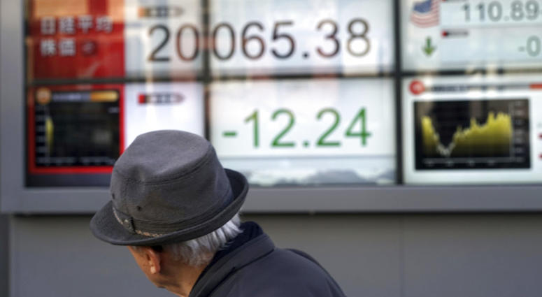 A man walks past an electronic stock board showing Japan's Nikkei 225 index at a securities firm in Tokyo Friday, Dec. 28, 2018. A man walks past an electronic stock board.