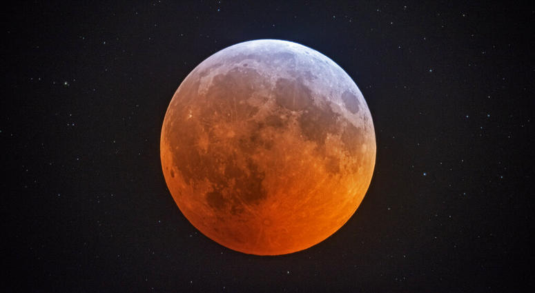 In this photo made with a 12-1/2 inch telescope and provided by Johnny Horne, the totally eclipsed moon glows with a reddish color against the background stars over Stedman, N.C., Monday, Jan. 21, 2019. The totally eclipsed moon glows with a reddish color against the background stars.