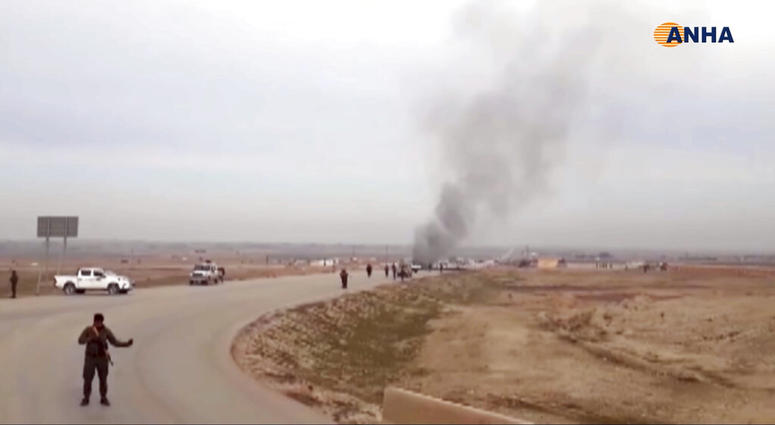 This frame grab from video provided by Hawar News, ANHA, the news agency for the semi-autonomous Kurdish areas in Syria, shows Kurdish fighters standing guard at the site of a suicide attack near the town of Shaddadeh, Jan. 21, 2019. This frame grab from video provided by Hawar News, ANHA, the news agency for the semi-autonomous Kurdish areas in Syria, shows Kurdish fighters standing guard at the site of a suicide attack near the town of Shaddadeh, Jan. 21, 2019.