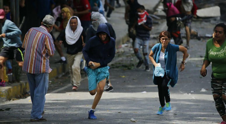 Anti-government protesters run during clashes with security forces as they show support for an apparent mutiny by a national guard unit in the Cotiza neighborhood of Caracas, Venezuela, Monday, Jan. 21, 2019. Anti-government protesters run during clashes with security forces as they show support for an apparent mutiny by a national guard unit in the Cotiza neighborhood of Caracas, Venezuela, Monday, Jan. 21, 2019.