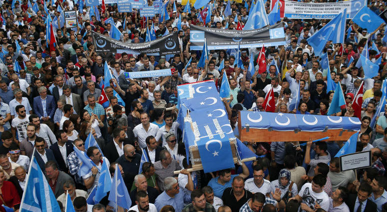 FILE - In this Saturday, July 4, 2015 file photo, Uighurs living in Turkey and their supporters, some carrying coffins representing Uighurs who died in China's far-western Xinjiang Uighur region, chant slogans as they stage a protest in Istanbul, against FILE - In this Saturday, July 4, 2015 file photo, Uighurs living in Turkey and their supporters, some carrying coffins representing Uighurs who died in China's far-western Xinjiang Uighur region, chant slogans as they stage a protest in Istanbul, against