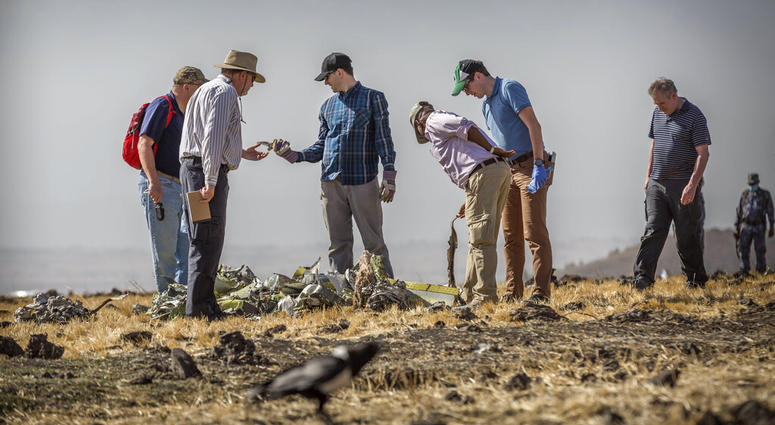Officials from the Aviation Industry Corporation of China pray March 12, 2019, next to offerings of fruit, breads and incense sticks, at the scene where the Ethiopian Airlines Boeing 737 Max 8 crashed shortly after takeoff. Officials from the Aviation Industry Corporation of China pray March 12, 2019, next to offerings of fruit, breads and incense sticks, at the scene where the Ethiopian Airlines Boeing 737 Max 8 crashed shortly after takeoff.