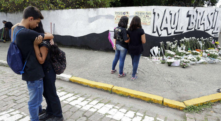 Relatives embrace next to the coffin containing the remains of 17-year-old Claiton Antonio Ribeiro, a victim of the mass shooting at the Raul Brasil State School, in Suzano, Brazil, Thursday, March 14, 2019. Relatives embrace next to the coffin containing the remains of 17-year-old Claiton Antonio Ribeiro, a victim of the mass shooting at the Raul Brasil State School, in Suzano, Brazil, Thursday, March 14, 2019.
