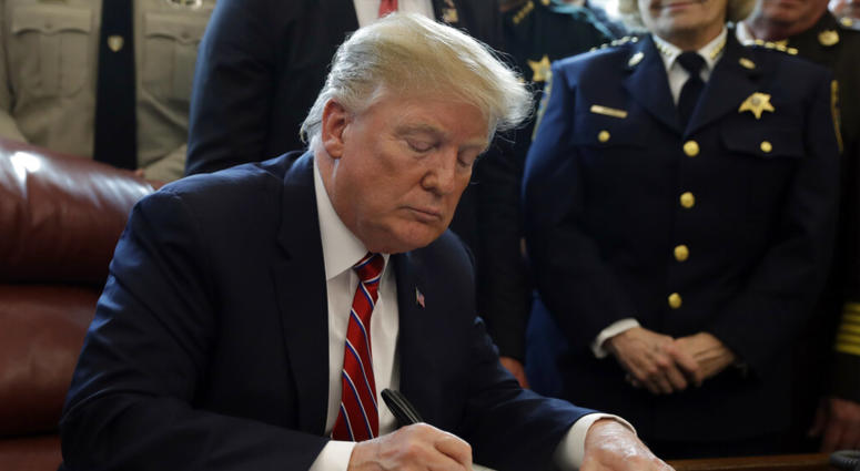 President Donald Trump signs the first veto of his presidency in the Oval Office of the White House, Friday, March 15, 2019/ President Donald Trump signs the first veto of his presidency in the Oval Office of the White House.