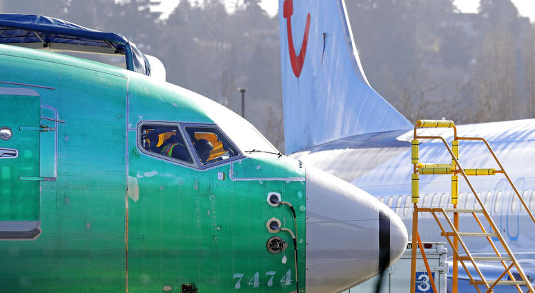 In this March 13, 2019, file photo a worker walks past an engine on a Boeing 737 MAX 8 airplane being built for American Airlines at Boeing Co.'s Renton assembly plant in Renton, Wash. An engine on a Boeing 737 MAX 8 airplane.