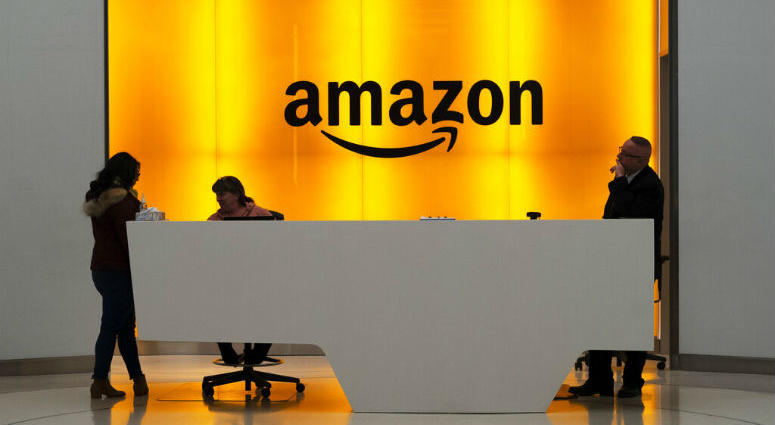 FILE - In this Feb. 14, 2019 file photo, people stand in the lobby for Amazon offices in New York. People stand in the lobby for Amazon offices in New York.