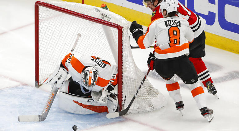 Chicago Blackhawks center Dylan Strome (17) tries to score against Philadelphia Flyers goaltender Carter Hart (79) and defenseman Robert Hagg (8) during the second period of an NHL hockey game Thursday, March 21, 2019, in Chicago. Philadelphia Flyers versus Chicago Blackhawks