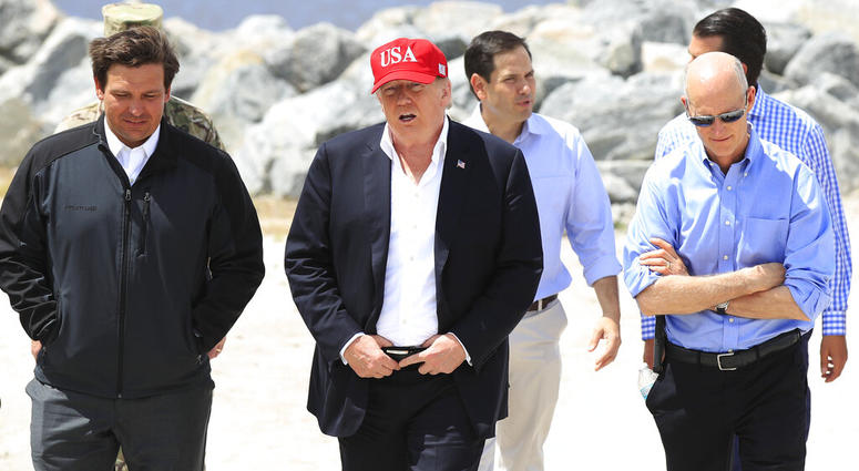 President Donald Trump walks with, from left, Florida Gov. Ron DeSantis, Sen. Marco Rubio, R-Fla., and Sen. Rick Scott, R-Fla., during a visit to Lake Okeechobee and Herbert Hoover Dike at Canal Point, Fla., Friday, March 29, 2019. President Donald Trump