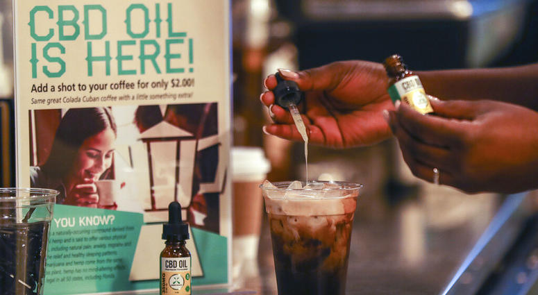 In this Friday, Jan. 4, 2018 file photo, a worker adds CBD oil to a drink at a coffee shot in Fort Lauderdale, Fla. CBD oil