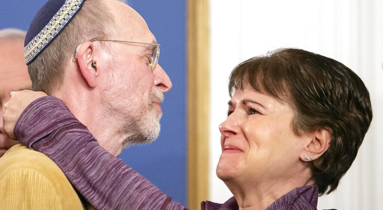 Daniel Leger, left, and Andrea Wedner, both survivors of the Tree of Life synagogue shooting, embrace after Pittsburgh Mayor Bill Peduto signed three gun-control bills into law, Tuesday, April 9, 2019, at the City-County Building in downtown Pittsburgh. Survivors of the Tree of Life synagogue shooting embrace.