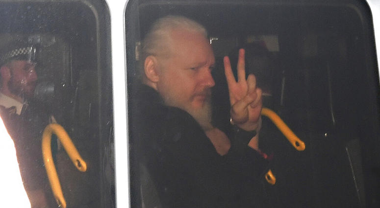 Julian Assange gestures as he arrives at Westminster Magistrates' Court in London, after the WikiLeaks founder was arrested by officers from the Metropolitan Police and taken into custody, April 11, 2019. Julian Assange