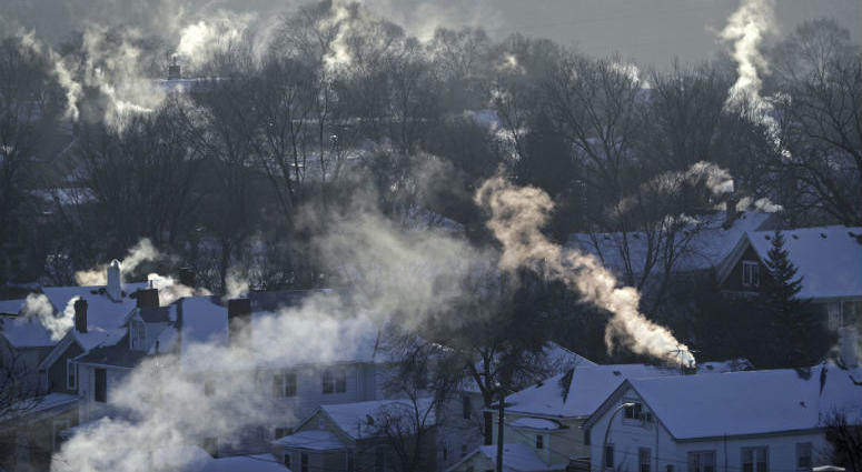FILE- In this Wednesday Jan. 30, 2019, file photo smoke rises from the chimneys of homes in St. Paul, Minn. Americans burned a record amount of energy in 2018, with a 10% jump in consumption from booming natural gas helping to lead the way, the U.S. Energy Information Administration says.