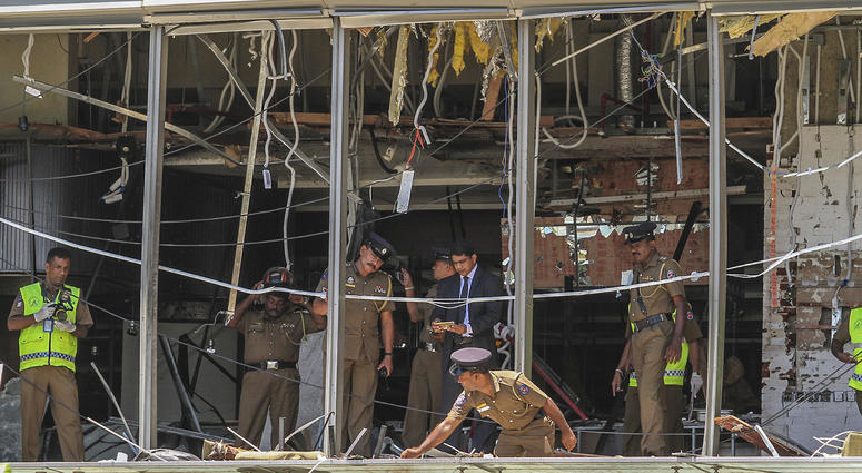 In this Sunday April 21, 2019, photo, a Sri Lankan Police officer inspects a blast spot at the Shangri-la hotel in Colombo, Sri Lanka. Sri Lanka
