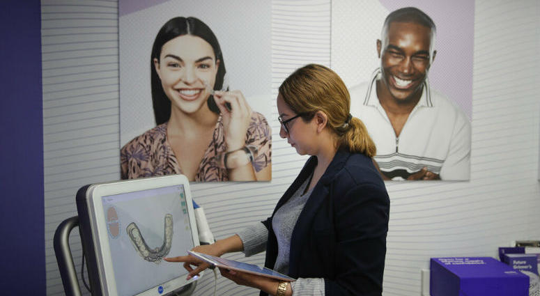 Dental assistant Jessica Buendia looks at a scanned image of patient's teeth in SmileDirectClub's SmileShop located inside a CVS store Wednesday, April 24, 2019, in Downey, Calif. CVS Health is venturing into dental care with plans to offer the relatively new teeth-straightening service.