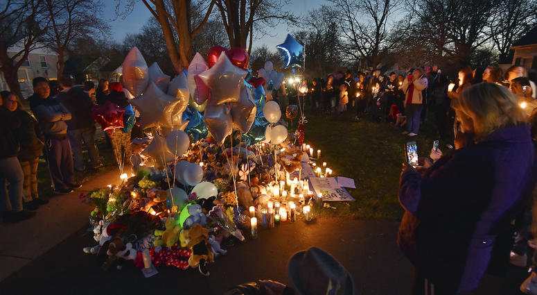 In this Wednesday, April 24, 2019 photo, community members in Crystal lake, Ill. hold a vigil in memory of 5-year-old Andrew "AJ" Freund. Andrew "AJ" Freund vigil