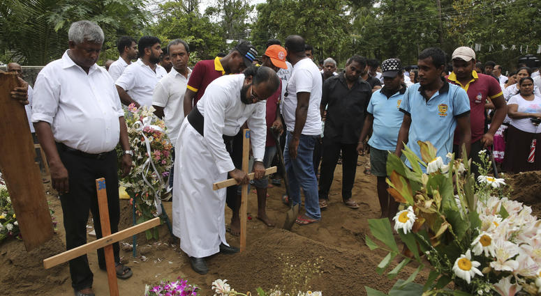 Father Niroshan Perera places a cross during the funeral service of Dhami Brandy, 13, who was killed during Easter Sunday's bomb blast at St. Sebastian Church, in Negombo, Sri Lanka Thursday, April 25, 2019. Sr Lanka funeral service
