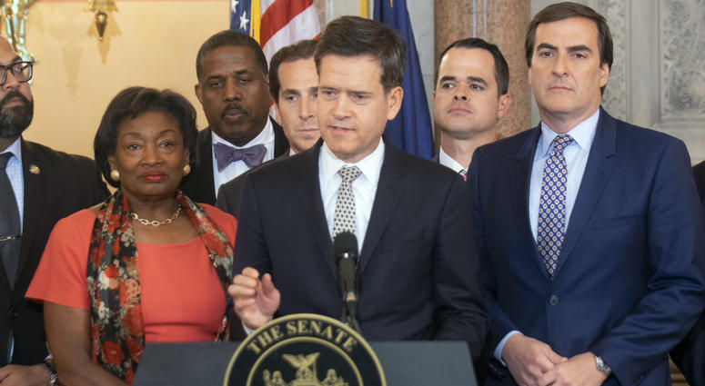 New York state Sen. Brad Hoylman, center, speaks during a news conference, May 8, 2019, at the Capitol in Albany, N.Y., about a Senate bill to authorize the release of individual New York state tax returns to Congress. New York senators