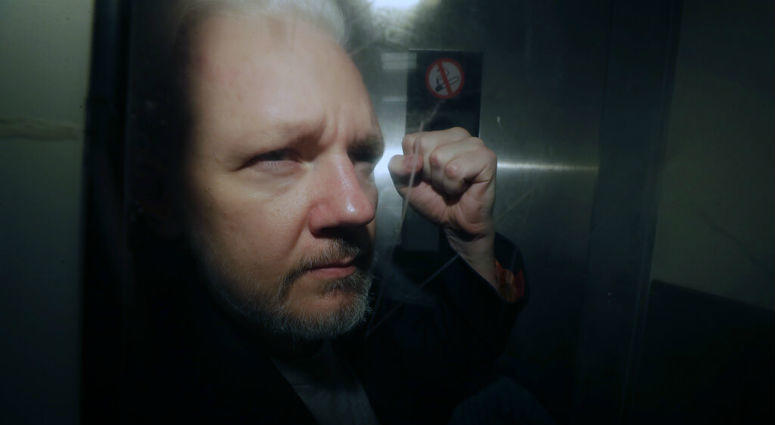 FILE - In this May 1, 2019, file photo, WikiLeaks founder Julian Assange puts his fist up as he is taken from court in London. The Justice Department has charged Assange with receiving and publishing classified information.