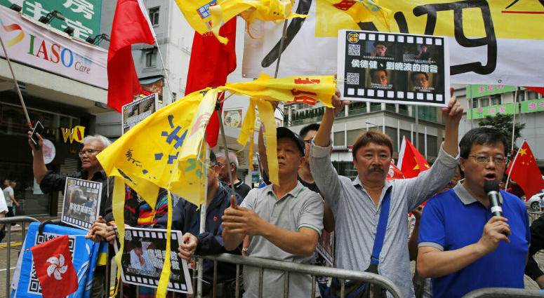Pro-Beijing supporters destroy yellow umbrellas, used to mark protesting denouncing far-reaching Beijing control, during a demonstration in Hong Kong, Sunday, May 26, 2019. A vigil will be held on June 4 at the Victoria Park to mark the 30th anniversary of the military crackdown on the pro-democracy movement at Beijing's Tiananmen Square on June 4, 1989.