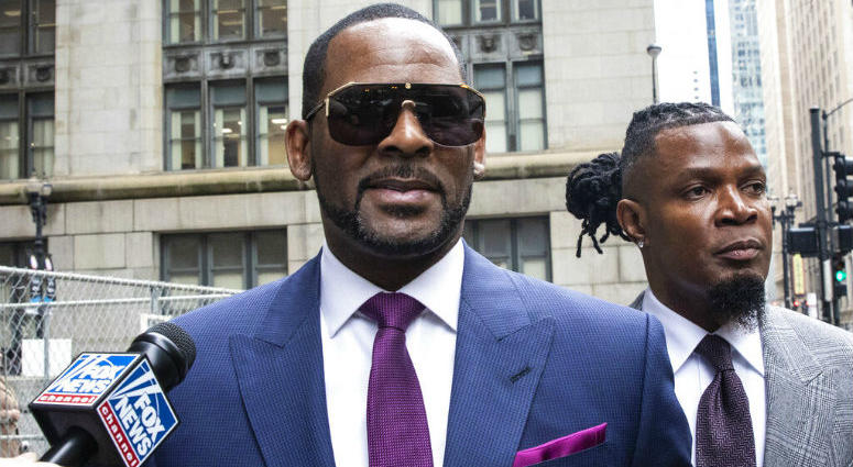 FILE - This March 13, 2019 file photo shows R. Kelly and his publicist Darryll Johnson, right, leaving The Daley Center after an appearance in court for Kelly's child support case in Chicago. Prosecutors in Chicago have charged Kelly with 11 new sex assault charges, some that are more serious than those first filed against him in February.