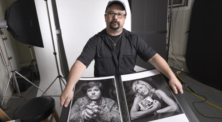 In this June 21, 2019, photo, Paul Gillespie, a photojournalist at the Capital Gazette newspaper, where five people were killed in a mass shooting in June 2018, holds a book of portraits he photographed of survivors and family members of those killed. In this June 21, 2019, photo, Paul Gillespie, a photojournalist at the Capital Gazette newspaper, where five people were killed in a mass shooting in June 2018, holds a book of portraits he photographed of survivors and family members of those killed.