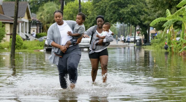 Jalana Furlough carries her son Drew Furlough as Terrian Jones carries Chance Furlough on Belfast Street near Eagle Street in New Orleans after flooding from a tropical wave system in the Gulf Mexico that dumped lots of rain in Wednesday, July 10, 2019. Jalana Furlough carries her son Drew Furlough as Terrian Jones carries Chance Furlough on Belfast Street near Eagle Street in New Orleans after flooding from a tropical wave system in the Gulf Mexico that dumped lots of rain in Wednesday, July 10, 2019.