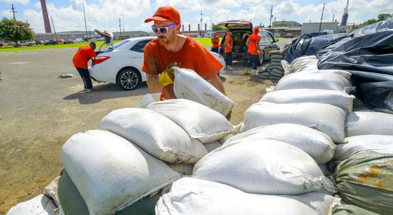 St. Bernard Parish Sheriff's Office inmate workers move free sandbags for residents in Chalmette, La., Thursday, July 11, 2019. The Mississippi Emergency Management Agency is telling people in the southern part of the state to be prepared for heavy rain from Tropical Storm Barry as it pushes northward through the Gulf of Mexico.