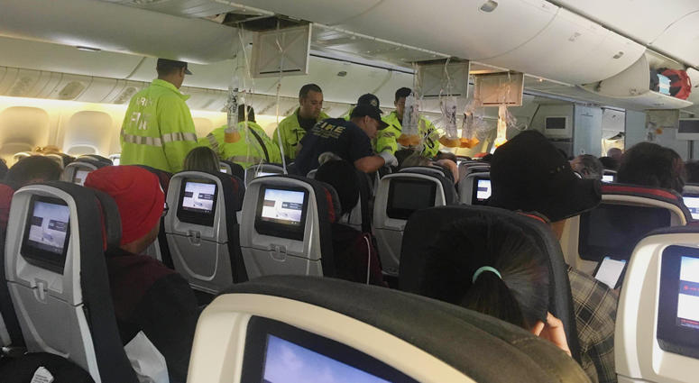 Responders treat a passenger on an Air Canada flight to Australia that was diverted and landed at Daniel K. Inouye International Airport in Honolulu on Thursday, July 11, 2019. Air Canada