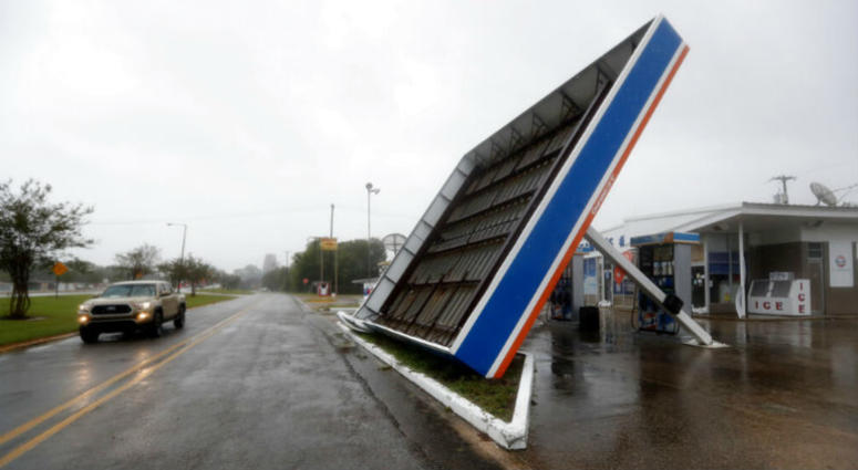 A vehicle passes a toppled gas pump canopy in Berwick, La., following a severe weather assault from Tropical Storm Barry, Saturday, July 13, 2019. Gulf Coast keeps guard up as Barry continues drenching